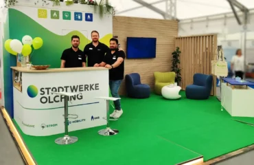 Mitarbeiter der Stadtwerke Olching stehen an einem Messestand der Stadtwerke Olching auf der FFB-Schau 2025.